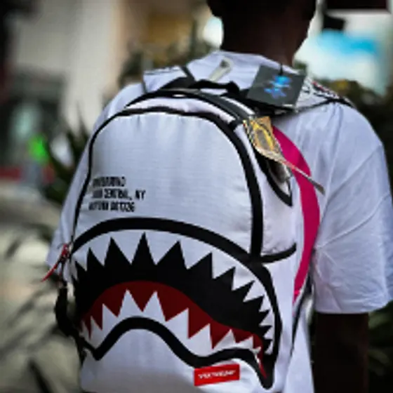 Morral Sprayground blanco de boca de tiburón puesto en la espalda